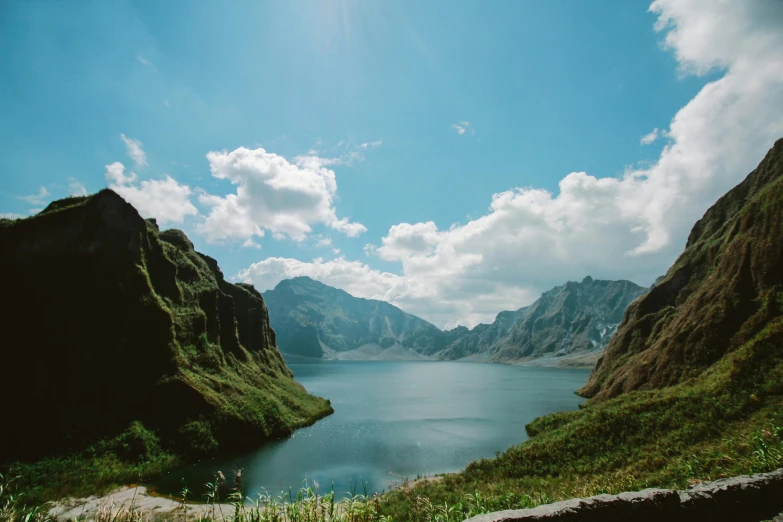 a large body of water surrounded by mountains, by Muggur, pexels contest winner, sumatraism, a photo of a lake on a sunny day, craggy, philippines, conde nast traveler photo