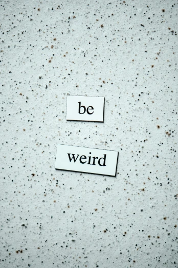 a sign that says be weird on a wall, inspired by Weiwei, trending on pexels, concrete poetry, magnetic, wizard, two