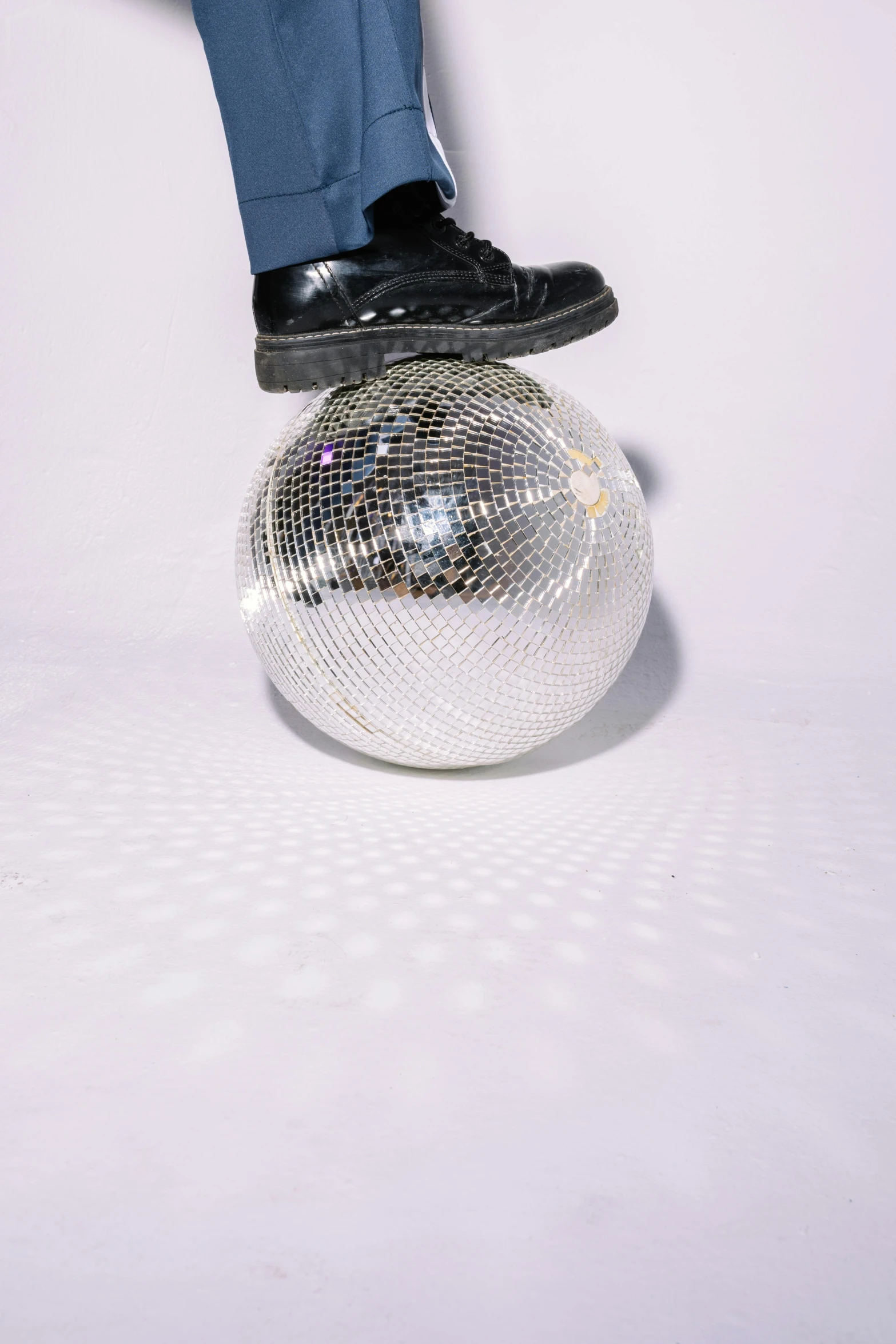 a man standing on top of a disco ball, an album cover, by Gavin Hamilton, trending on pexels, white shoes, low detailed, view from below, on a pale background