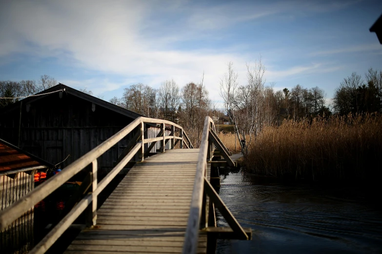 a wooden bridge over a body of water, a picture, by Jesper Myrfors, hurufiyya, taken with sony alpha 9, full frame image, hamar, college
