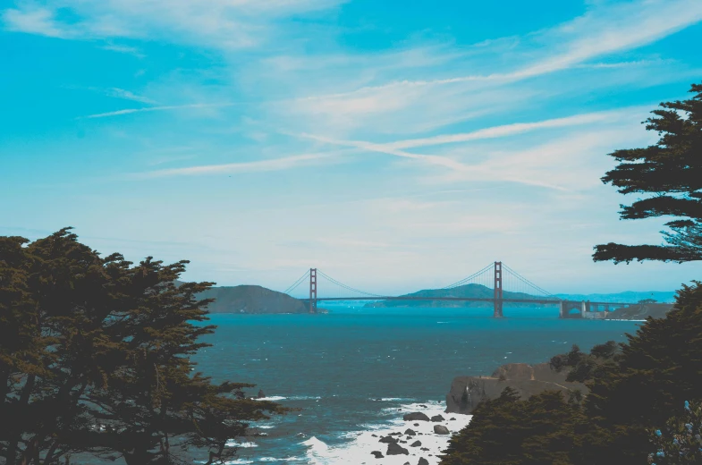 a view of a bridge over a body of water, pexels contest winner, brown and cyan blue color scheme, bay area, background image, hills and ocean