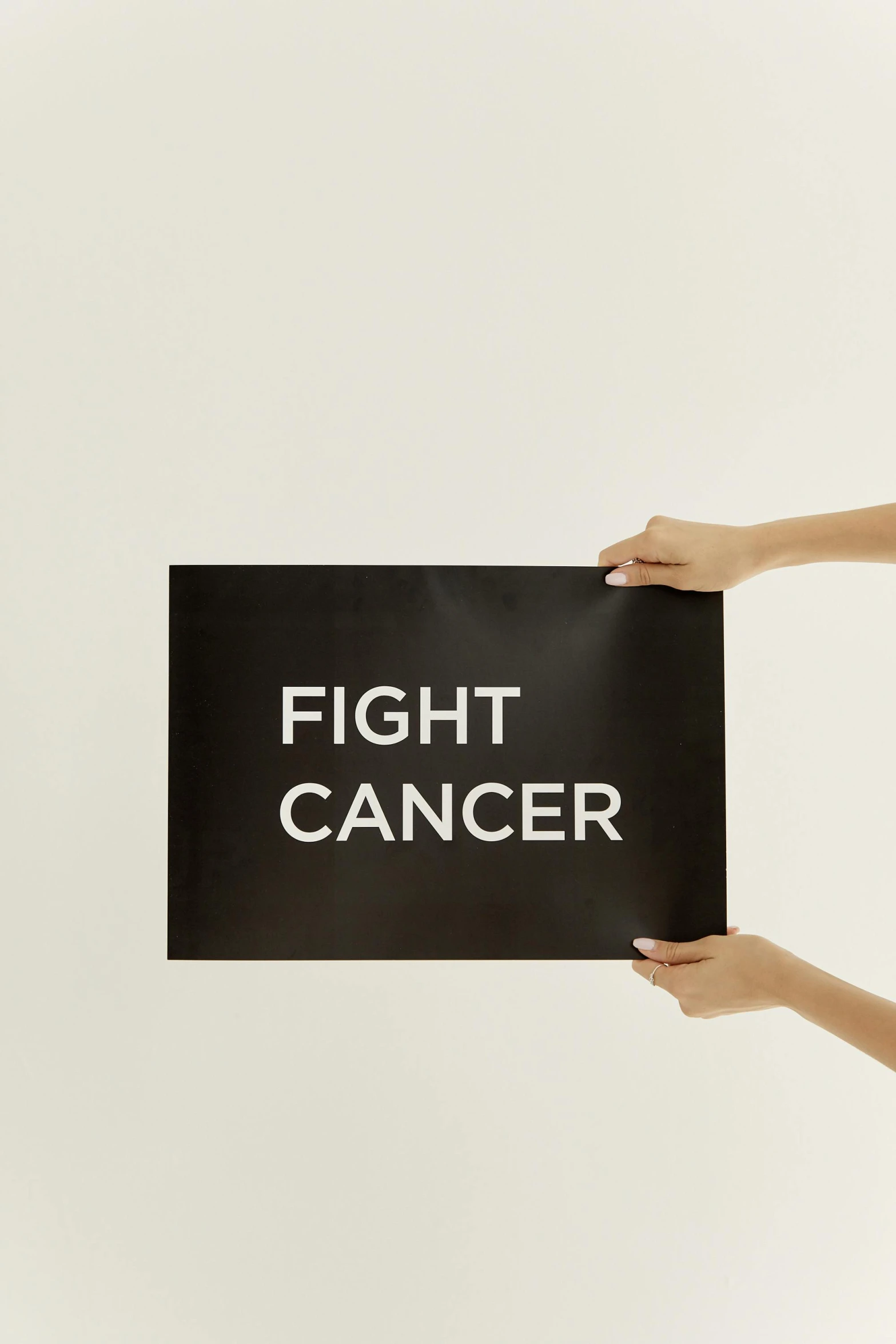 a woman holding a sign that says fight cancer, poster art, by Julia Pishtar, pexels contest winner, matte black paper, courtesy of moma, detail shot, light box