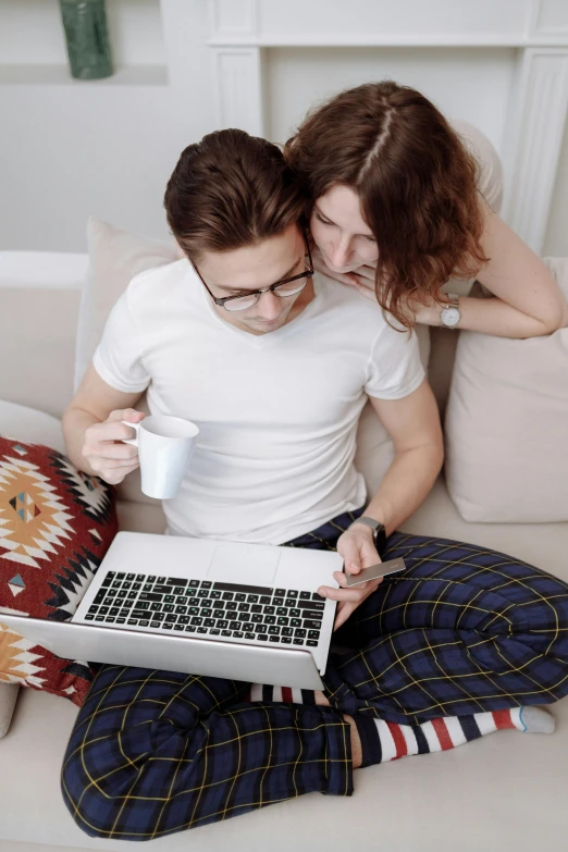 a man and woman sitting on a couch with a laptop, trending on pexels, renaissance, russian girlfriend, wearing white pajamas, lesbians, coding