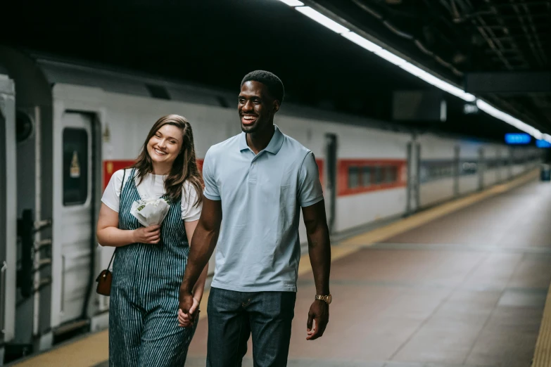 a man and a woman walking next to a train, mkbhd, fan favorite, subway station, smiling couple