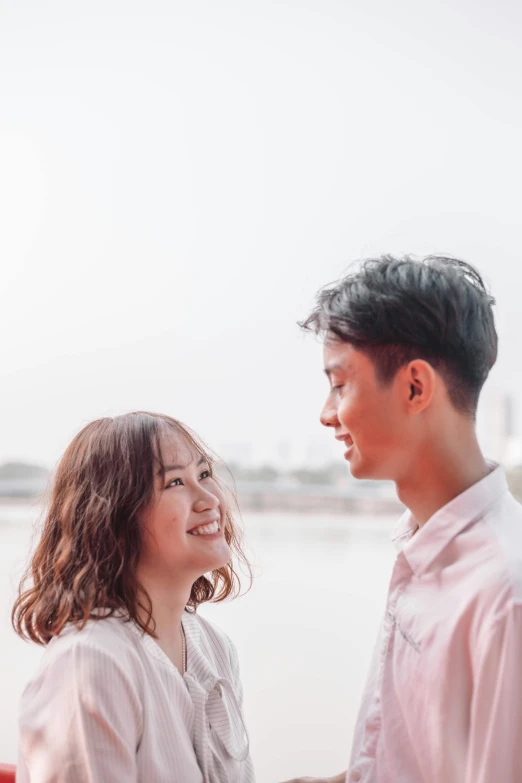 a man and a woman standing next to each other, by Tan Ting-pho, pexels contest winner, happening, mid long hair, slightly smiling, profile pic, river in the background