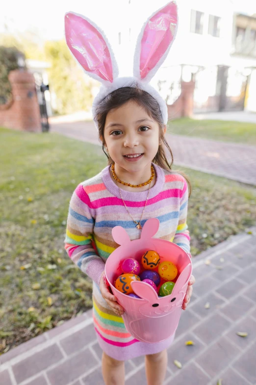 a little girl in bunny ears holding a basket of eggs, pexels contest winner, square, standing outside a house, candy girl, spanish