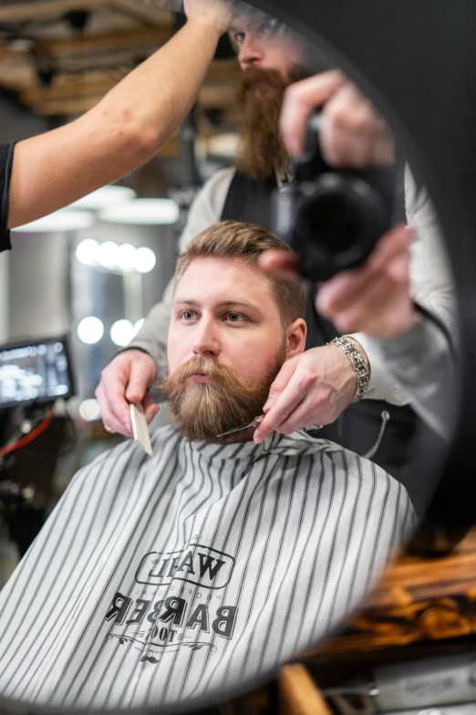 a man getting his hair cut at a barber shop, a portrait, by Daarken, sharp jawline with a light beard, tuomas korpi and wlop, square, raw file