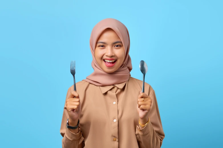 a woman in a hijab holding a fork and knife, pexels contest winner, dau-al-set, blue background colour, happy friend, aaaaaaaaaaaaaaaaaaaaaa, brown