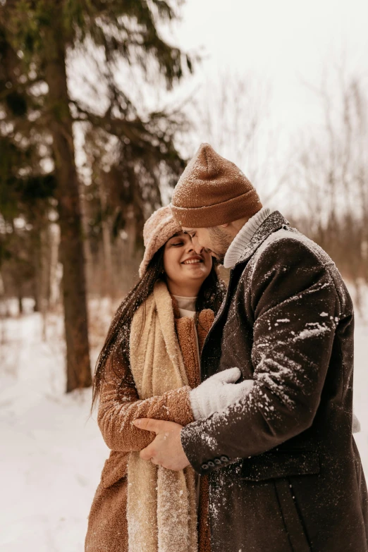 a man and woman standing next to each other in the snow, a picture, pexels contest winner, hugging, brown, profile pic, wearing wool hat