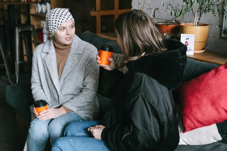 a couple of women sitting on top of a couch, trending on pexels, hurufiyya, beanie, faces of too much caffeine, jodie bateman, wearing a head scarf