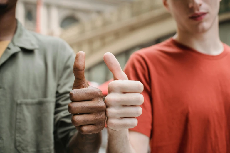 two men standing next to each other giving thumbs up, by Matija Jama, trending on pexels, institutional critique, brown, 🦩🪐🐞👩🏻🦳, mix of ethnicities and genders, slightly red