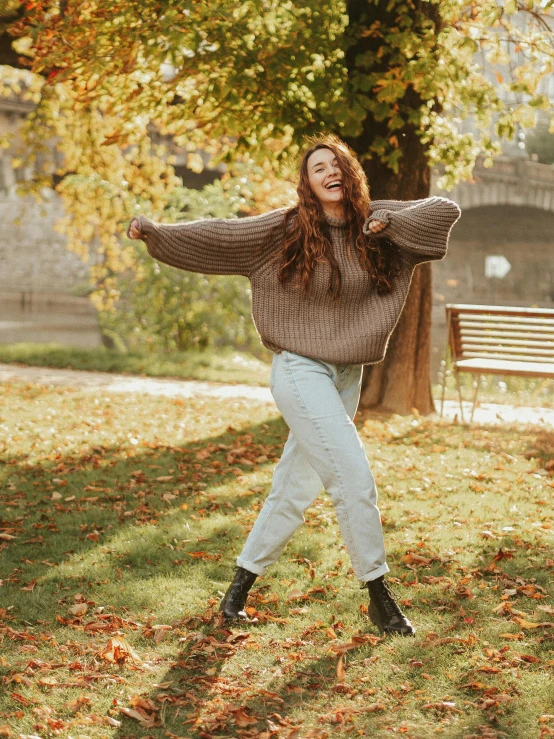 a woman standing on top of a lush green field, pexels contest winner, happening, wearing casual sweater, smiling and dancing, 🍂 cute, modelling