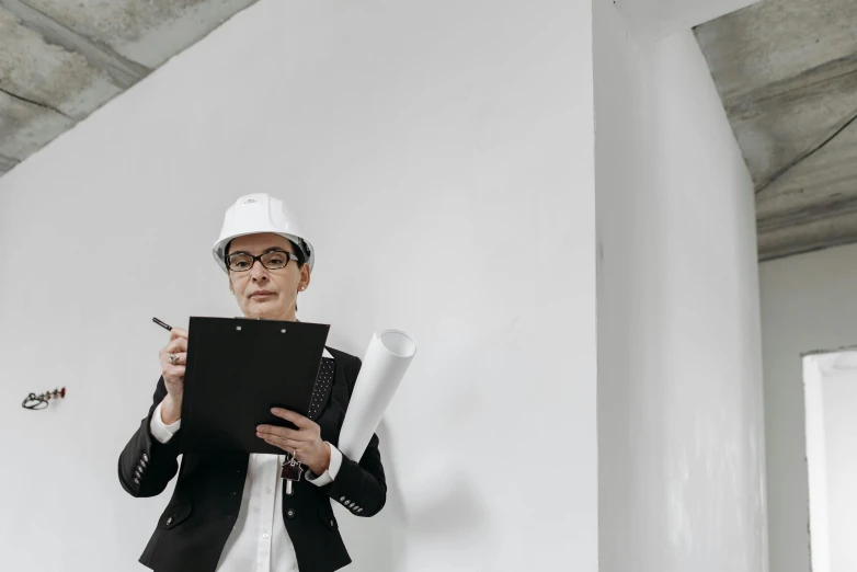 a man in a hard hat holding a clipboard, pexels contest winner, bauhaus, white wall complex, woman in business suit, whiteboards, background image