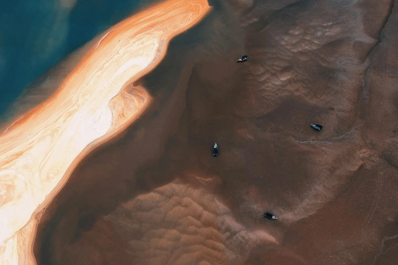 a group of people riding surfboards on top of a sandy beach, pexels contest winner, surrealism, chocolate river, view from space, desert colors, iceland