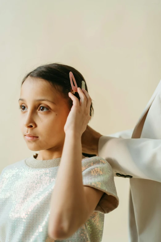 a woman is combing another woman's hair, an album cover, trending on pexels, indian girl with brown skin, greta thunberg, wearing lab coat and a blouse, at a fashion shoot