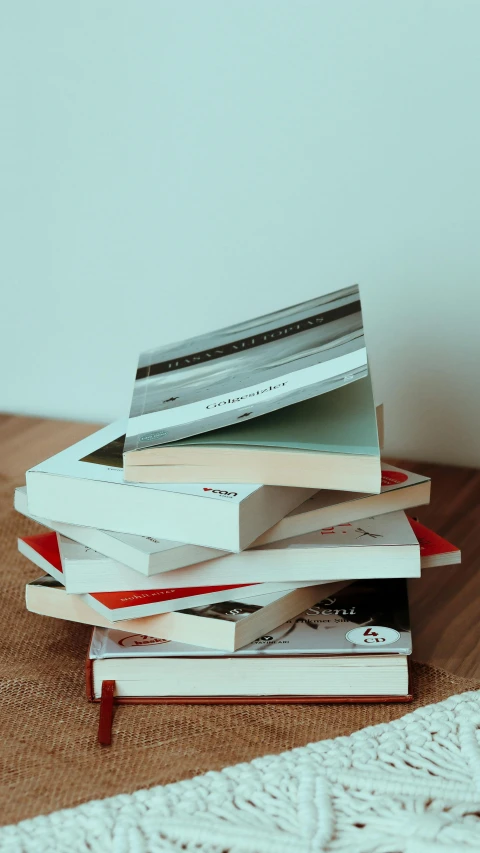 a stack of books sitting on top of a wooden table, thumbnail, - 6, leaked image