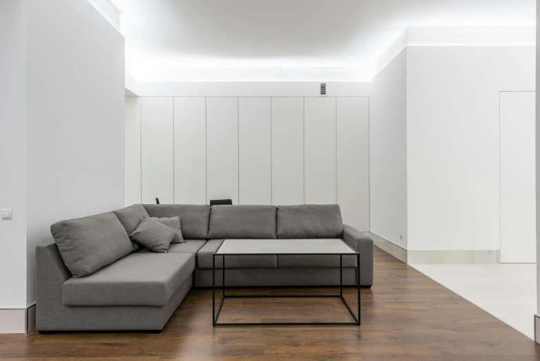 a living room with a couch and a coffee table, by Adam Marczyński, light and space, minimalist lighting, glossy white metal, medium height, minimalist