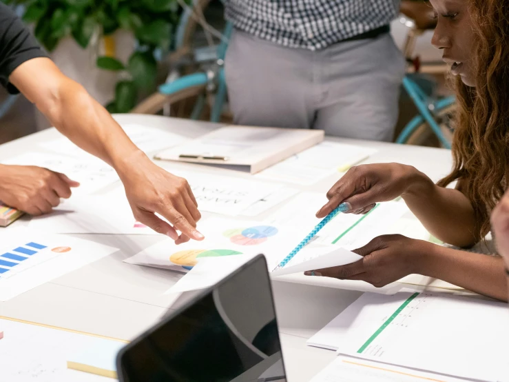 a group of people sitting around a white table, pexels contest winner, analytical art, 9 9 designs, papers on table, schools, vp of marketing