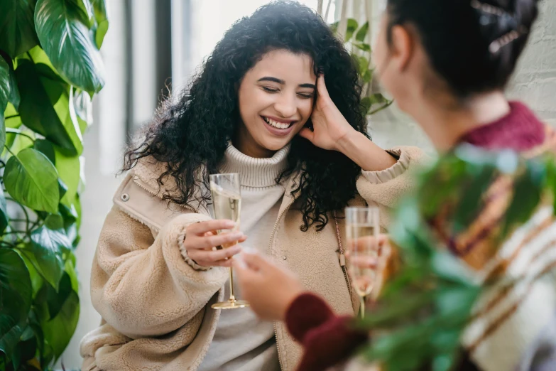 a woman holding a glass of wine next to another woman, trending on pexels, happening, bubbly, imaan hammam, she is smiling and excited, winter vibes