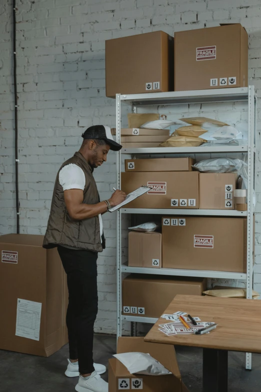 a man standing in front of a stack of boxes, inspect in inventory image, influencer, brown, riyahd cassiem