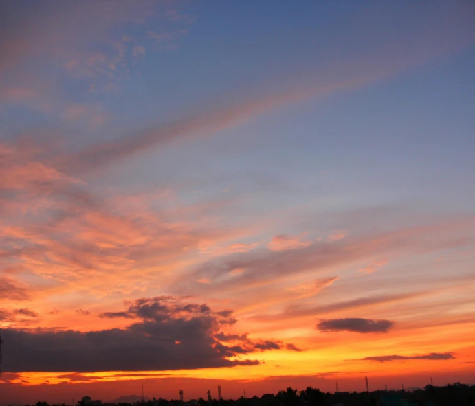 a large body of water with a sunset in the background, the sky