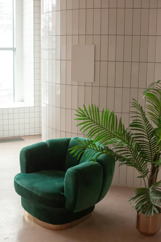 a living room with a green chair and a potted plant, inspired by Constantin Hansen, trending on unsplash, modernism, tiled, curved. studio lighting, profile image, tourist photo