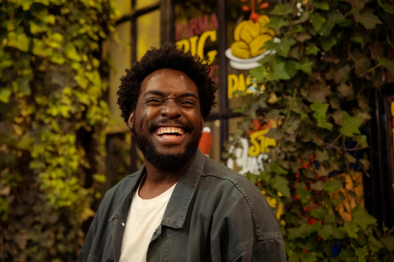 a man that is standing in front of a building, a picture, large black smile, playful smirk, portrait featured on unsplash, jaylen brown