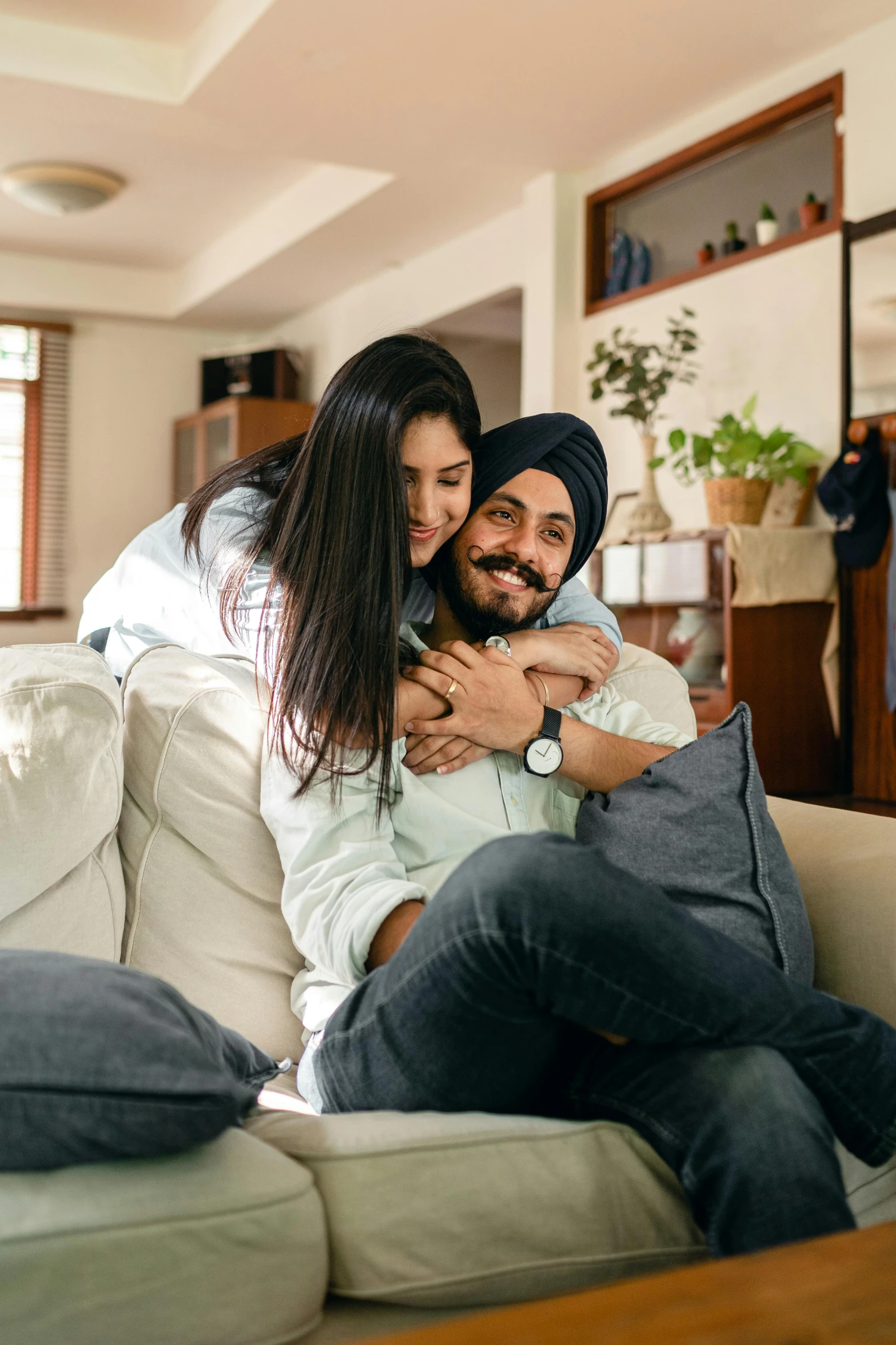 a man and a woman sitting on a couch, inspired by Manjit Bawa, pexels contest winner, hugging each other, at home, thumbnail, asian male