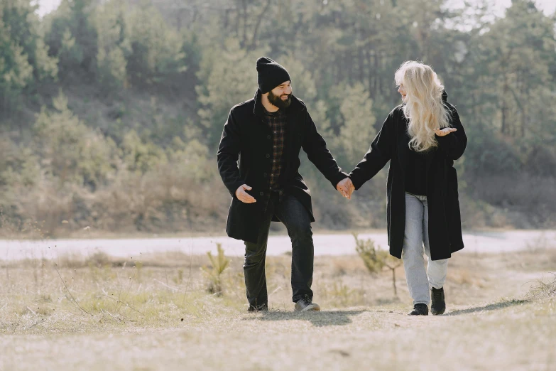 a man and a woman holding hands in a field, pexels contest winner, wearing jeans and a black hoodie, a blond, ghutra and egal, profile image