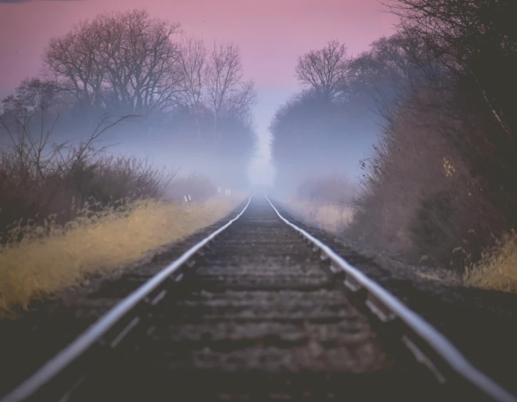 a train track in the middle of a foggy field, pexels contest winner, romanticism, faded pink, dusk setting, instagram post, purple fog