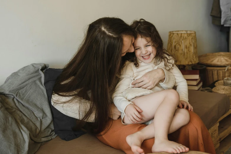 a woman sitting on top of a couch holding a little girl, pexels contest winner, brunettes, avatar image, happy cozy feelings, girl with brown hair