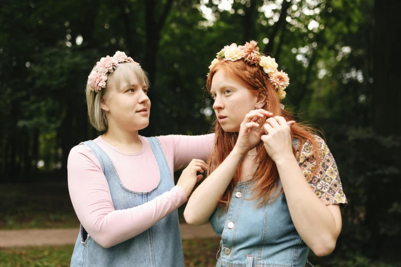 a couple of women standing next to each other, by Zofia Stryjenska, pexels, renaissance, flower crown, awkward, in a park, 15081959 21121991 01012000 4k