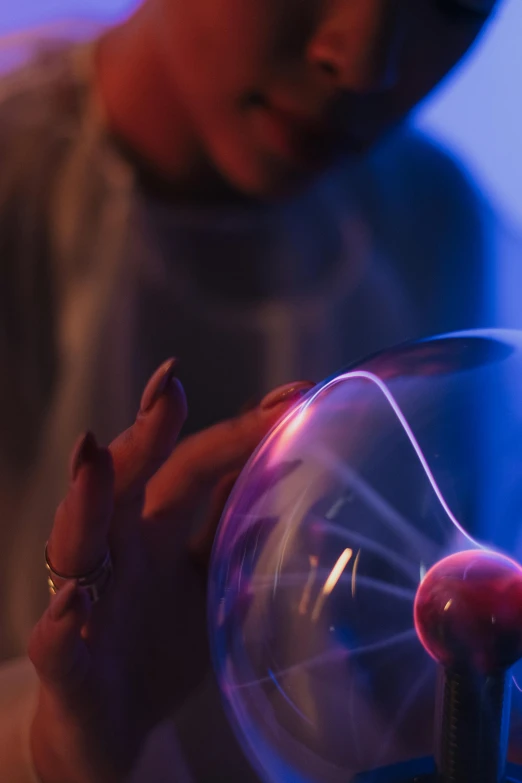 a close up of a person holding a light bulb, a hologram, kinetic art, pink and blue lighting, orrery, beakers, experimental