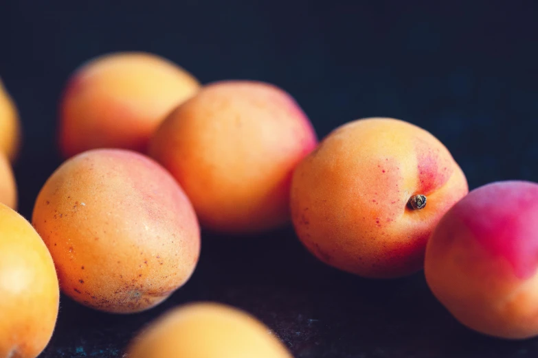 a pile of apricots sitting on top of a table, unsplash, background image, close - up photo, instagram post, round-cropped