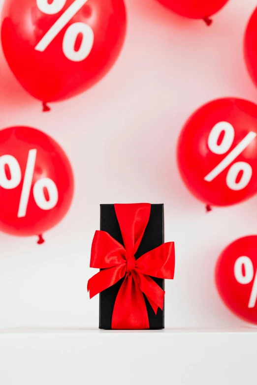 a black box with a red ribbon tied to it surrounded by red balloons, a cartoon, by Julia Pishtar, trending on unsplash, mathematical, sephora, proportions off, sales