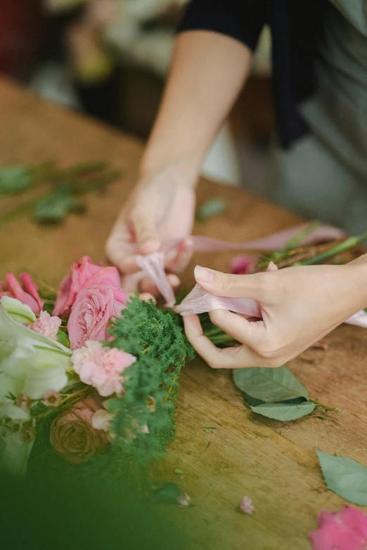 a close up of a person cutting flowers on a table, bows, pinks, subtle detailing, fresh