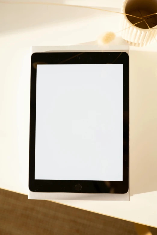 a tablet computer sitting on top of a table, by Carey Morris, smooth translucent white skin, panel of black, square face, very bright white light