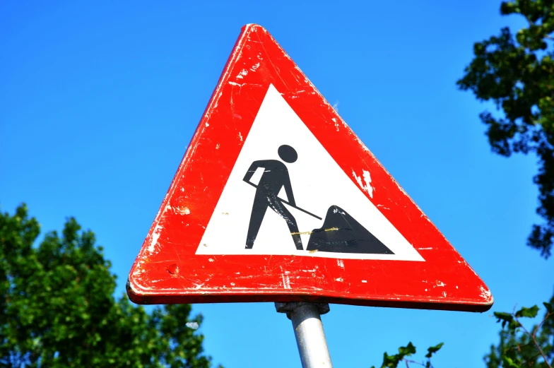 a close up of a street sign with trees in the background, a cartoon, unsplash, happening, bright construction materials, triangle, digging, figures