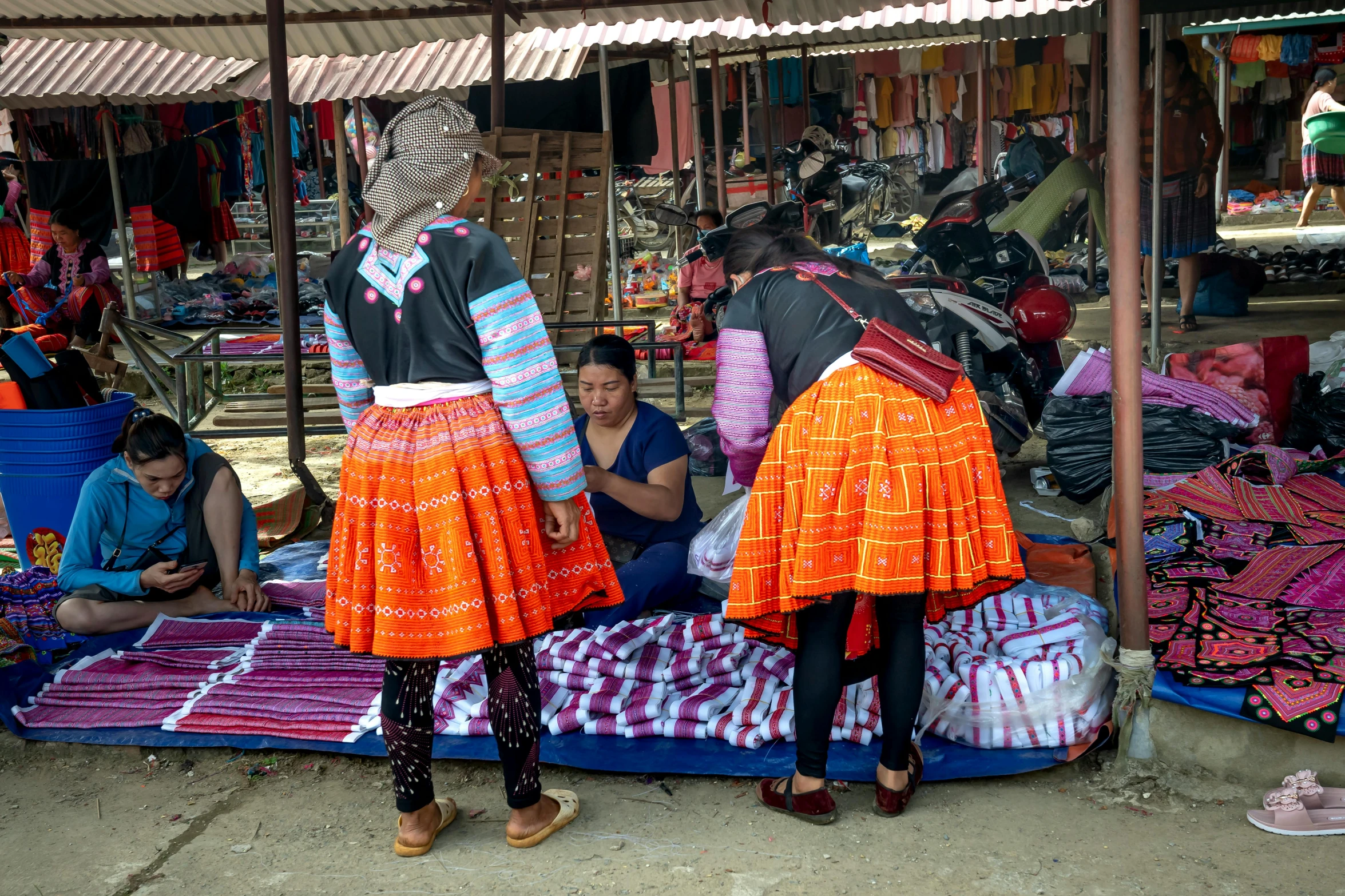 a group of women standing next to each other at a market, trending on unsplash, cloisonnism, bright red cape on her back, square, girls resting, fabrics and textiles