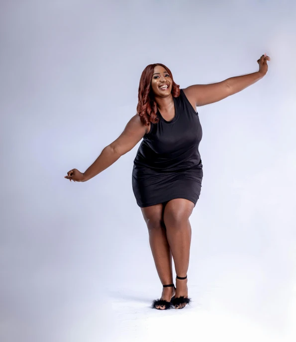 a woman in a black dress posing for a picture, by Chinwe Chukwuogo-Roy, pexels, happening, obese ), she is dancing. realistic, 15081959 21121991 01012000 4k, solid background