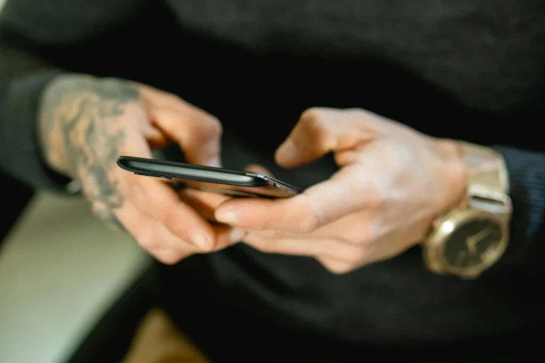 a close up of a person holding a cell phone, a tattoo, trending on pexels, happening, avatar image, maintenance, 1 5 0 4, sleek hands