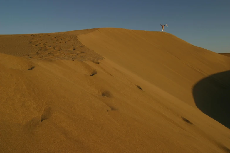 a person standing on top of a sand dune, very long shot of a windmill, sitting on a martian rock, 1km tall, sand banks