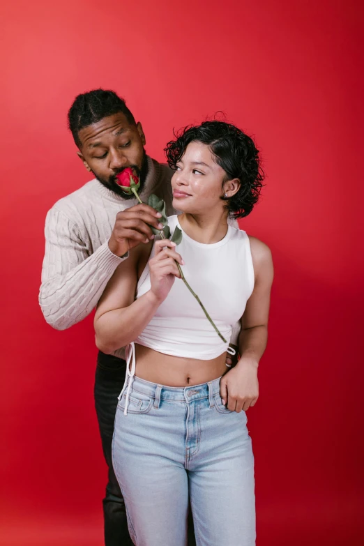 a man standing next to a woman holding a rose, by Cosmo Alexander, trending on pexels, renaissance, mixed race, playful pose, dating app icon, studio photo