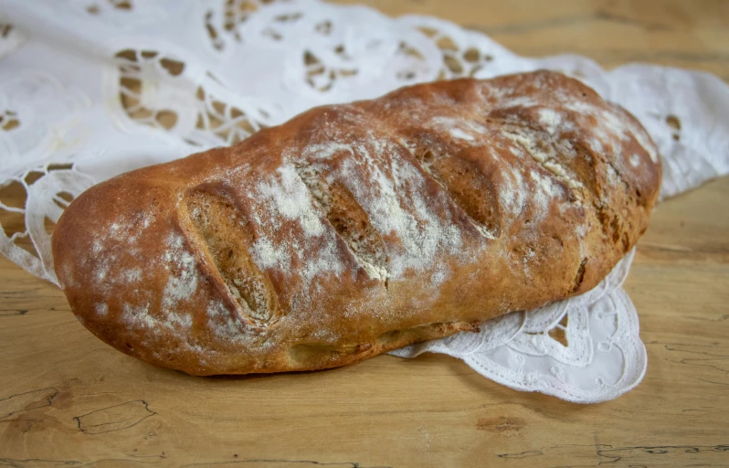 a loaf of bread sitting on top of a table, caparisons, quintessa, covered in white flour, detailed product image