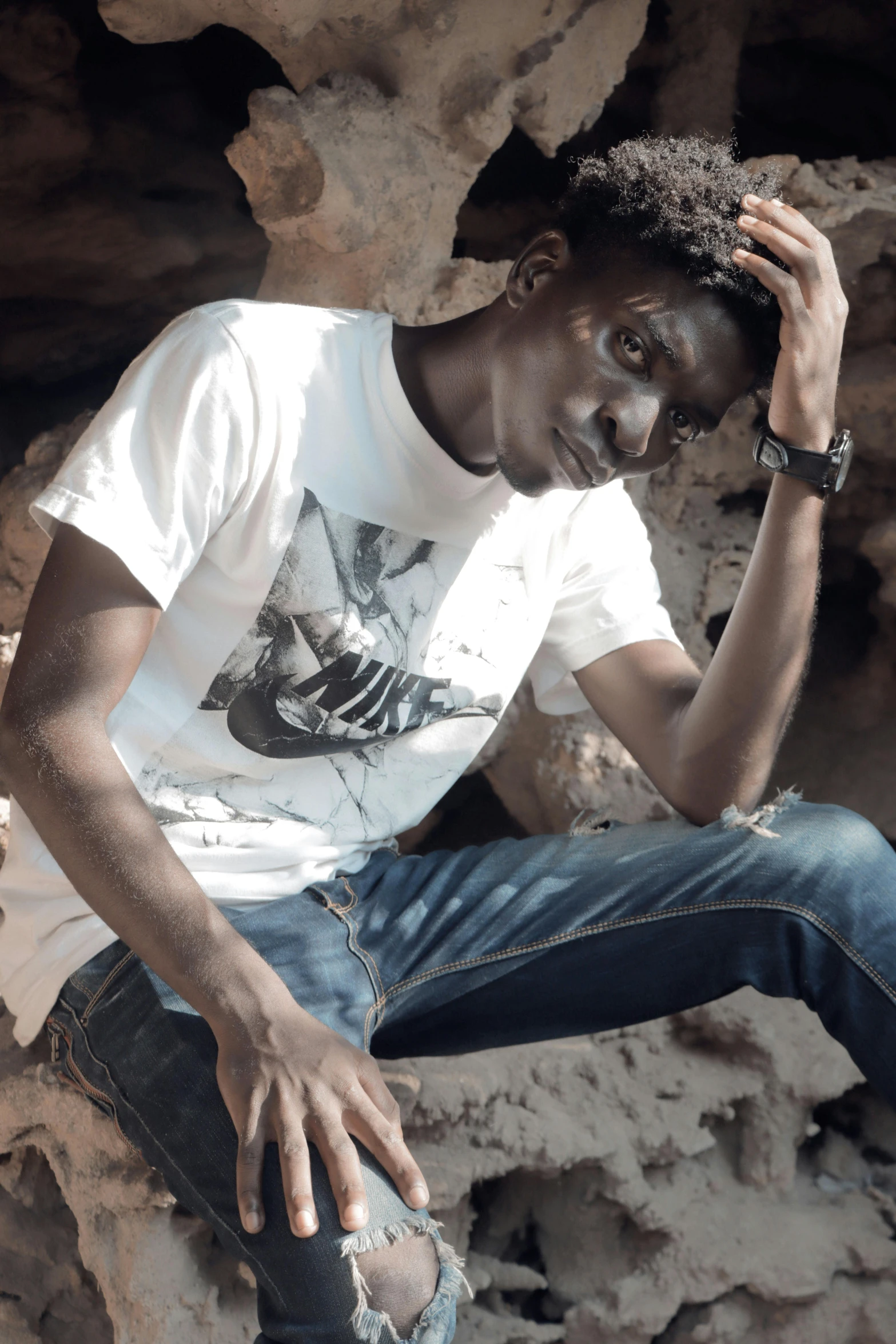 a man sitting on a rock with a skateboard, by Charly Amani, happening, jeans and t shirt, kano), ((portrait)), sad look