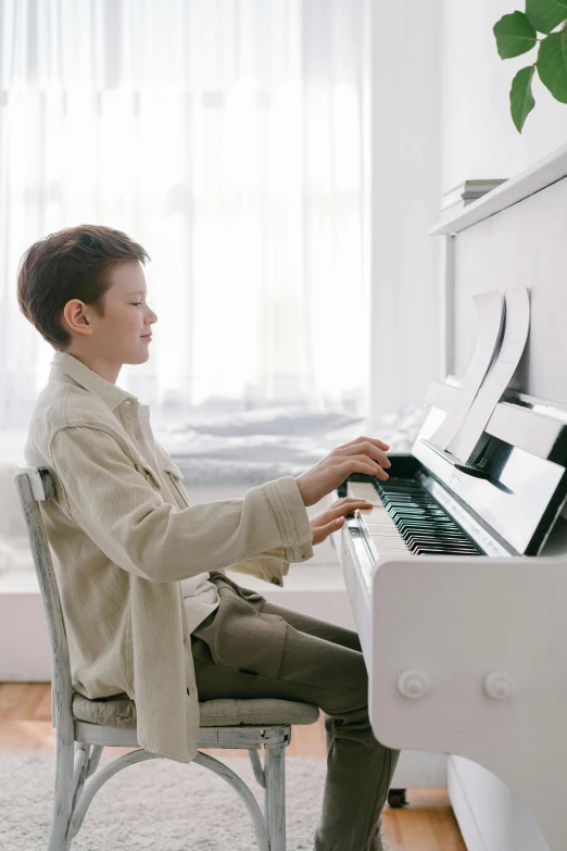 a boy sitting on a chair playing a piano, in a white room, promo image, premium, profile picture