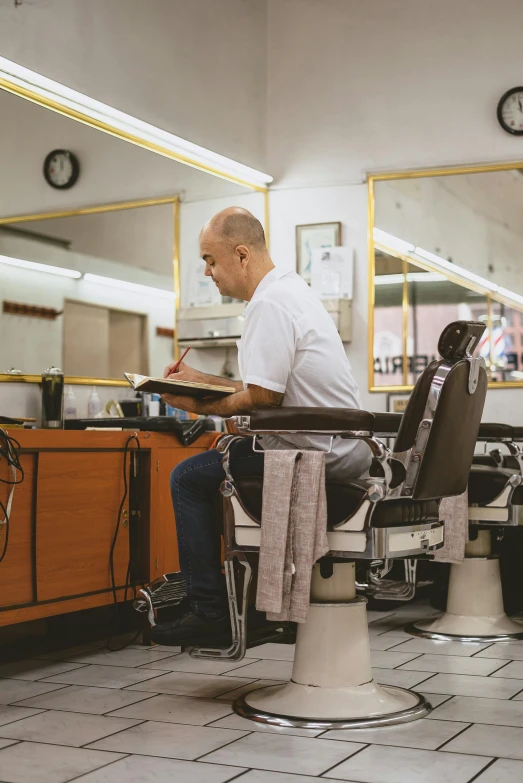 a man sitting in a chair in a barber shop, profile image