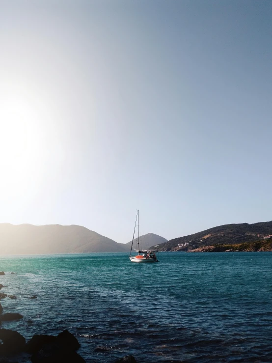 a couple of boats floating on top of a body of water, by Alexis Grimou, pexels contest winner, sun dappled, greek fantasy panorama, sailboat, a cozy