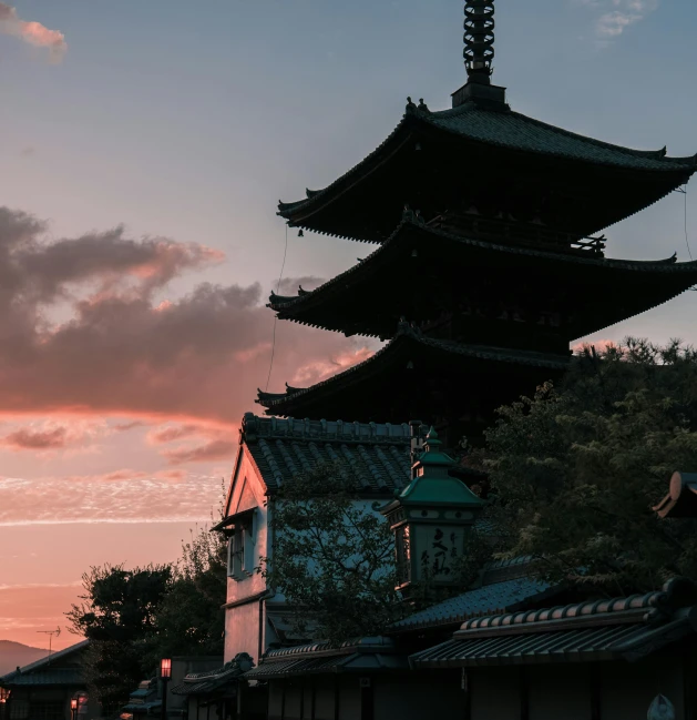 a person sitting on a bench in front of a pagoda, inspired by Itō Jakuchū, pexels contest winner, the sun is setting, japanese neighborhood, pink marble building, medieval japan