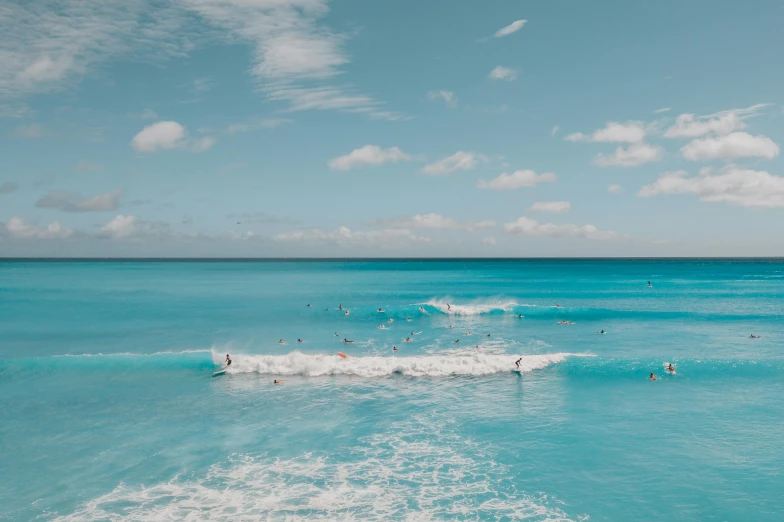 a group of people riding surfboards on top of a wave, pexels contest winner, minimalism, carribean turquoise water, shades of blue and grey, blue slide park, a photo of the ocean